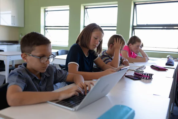 Iskolások Különböző Csoportjainak Oldalnézete Asztaloknál Ülve Személyi Számítógéppel Olvasással Írással — Stock Fotó