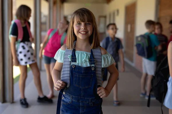 Portrait Caucasian Schoolgirl Wearing Dungarees Rucksack Standing Schoolyard Elementary School — 스톡 사진