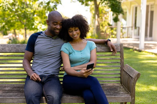 Vista Frontal Una Pareja Razas Mixtas Sentados Banco Jardín Sonriendo —  Fotos de Stock