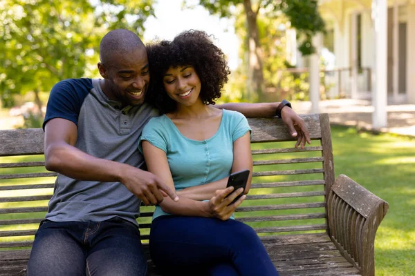 Vista Frontal Una Pareja Razas Mixtas Sentados Banco Jardín Sonriendo — Foto de Stock