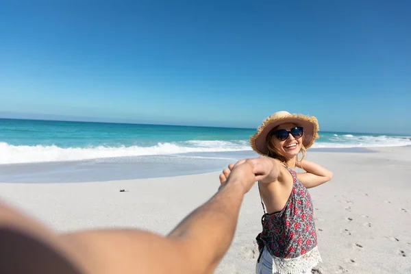 青い空と海に囲まれたビーチに立つ白人夫婦の正面の景色 手を取り合って微笑む — ストック写真