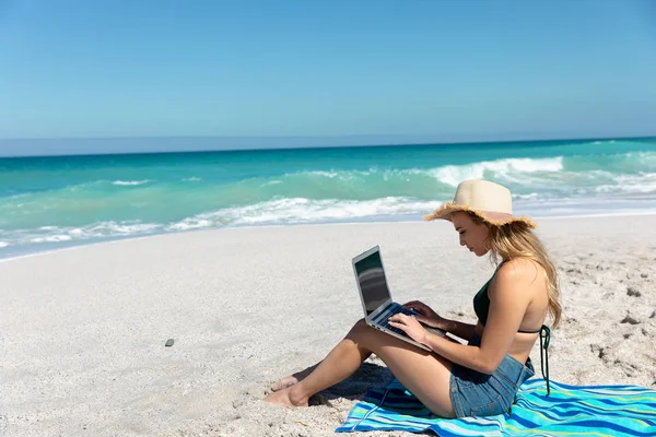 Widok Boku Białą Kobietę Siedzącą Ręczniku Plaży Słomkowym Kapeluszu Błękitnym — Zdjęcie stockowe