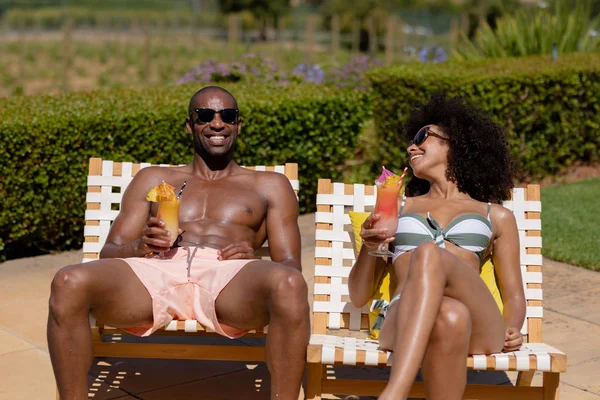Front View Mixed Race Couple Sitting Garden Beachwear Sunglasses Sunbathing — Stock Photo, Image