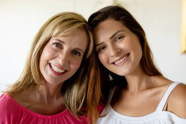 一个白人妇女和她的成年女儿在家里的特写 站在客厅里抱着 触摸着头 看着镜头笑着 — 图库照片