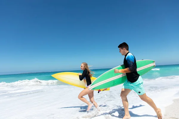 Vista Lateral Una Pareja Caucásica Corriendo Por Playa Con Cielo — Foto de Stock