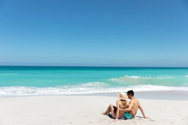 一对白种人夫妇斜倚在沙滩上 背景是蓝天蓝海 相拥相望 相望遥远的后视镜 — 图库照片