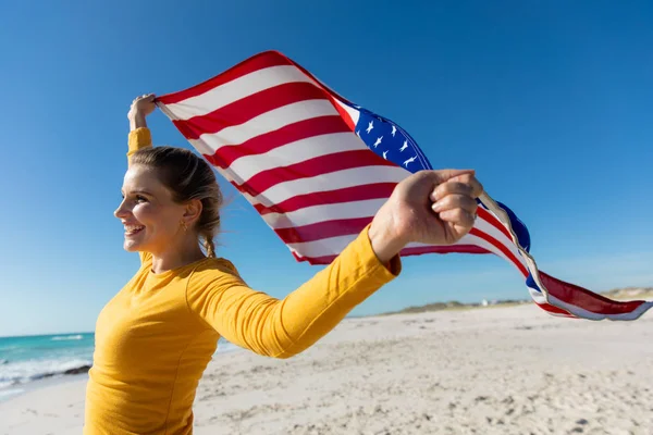 Vista Lateral Una Mujer Caucásica Desplegando Bandera Americana Pie Playa — Foto de Stock