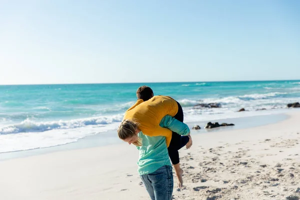 一对白种人夫妇站在海滩上 背景是蓝天和大海 背靠背 玩得很开心的背影 — 图库照片