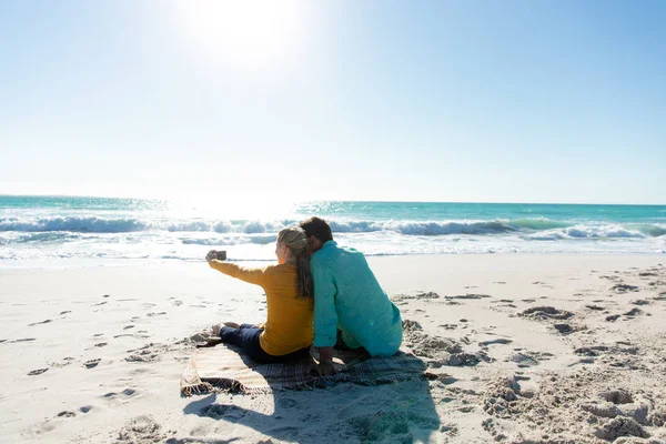 Bakifrån Ett Kaukasiskt Par Som Ligger Stranden Med Blå Himmel — Stockfoto