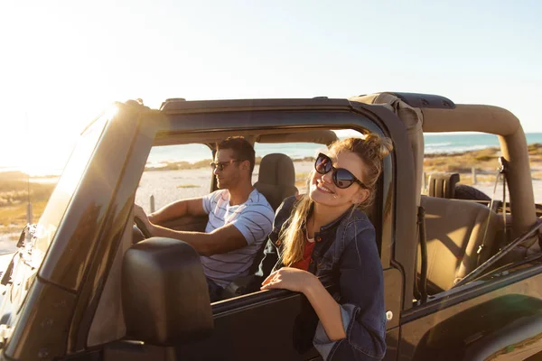 一对白种人夫妇坐在敞篷汽车里 开车的男人 女人笑着从车窗往外看的侧视图 — 图库照片