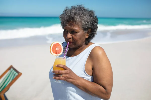 Widok Przodu Starszej Afroamerykanki Plaży Stojącej Słońcu Pijącej Koktajl Uśmiechniętej — Zdjęcie stockowe