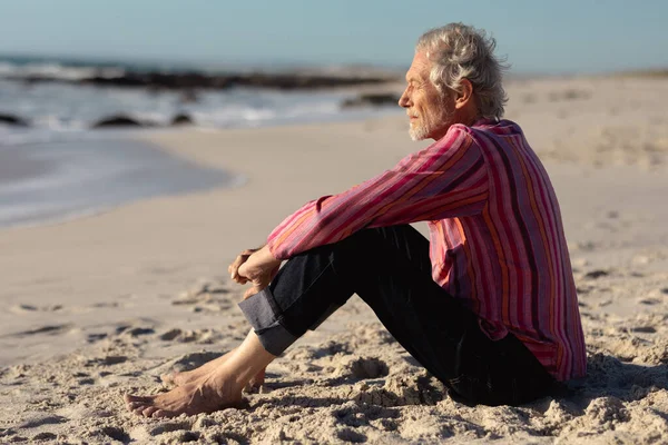 Vista Laterale Uomo Caucasico Anziano Spiaggia Sole Seduto Sulla Sabbia — Foto Stock