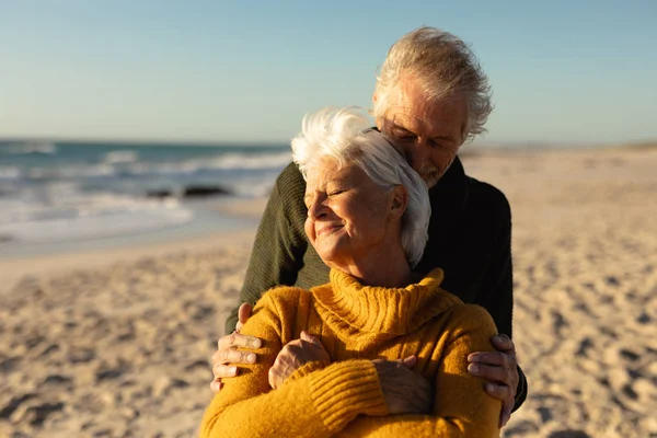 Front View Senior Caucasian Couple Beach Wearing Sweaters Embracing Smiling — Stock Photo, Image