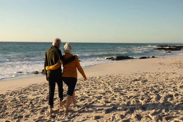 Vista Trasera Una Pareja Ancianos Caucásicos Playa Con Suéteres Abrazando — Foto de Stock