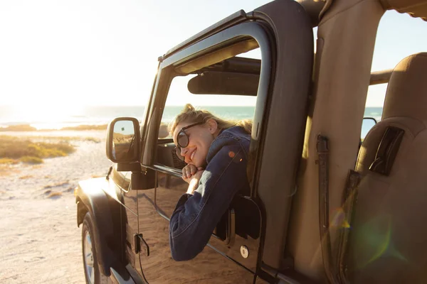 一个白人女人坐在敞着的顶层车里 透过窗户看去 面带微笑 周末海滩度假 生活方式和休闲 — 图库照片