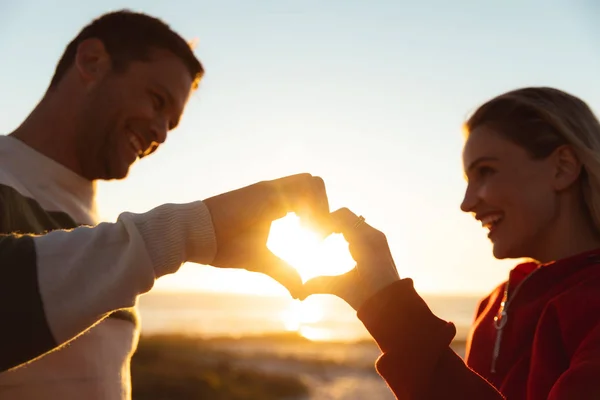 眼前是一对白种人夫妇 面带微笑 手牵着手形成心形 周末海滩度假 生活方式和休闲 — 图库照片