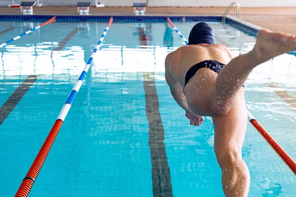 Zadní Pohled Bělošského Plavce Bazénu Skákání Startovního Bloku Ponoření Vody — Stock fotografie