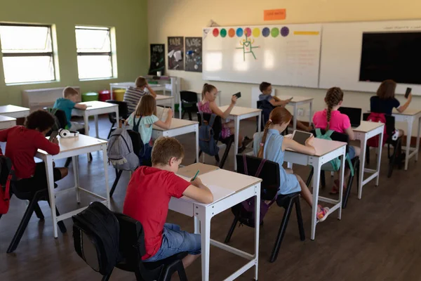 Niños Primaria Vista Alto Ángulo Grupo Diverso Escolares Sentados Escritorios —  Fotos de Stock