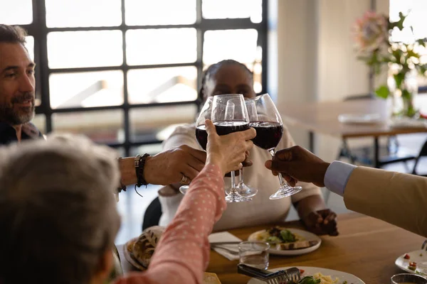 料理教室での上級多民族グループのサイドビュー テーブルで一緒にリラックスし 赤ワインのグラスを持ち トーストを作る — ストック写真
