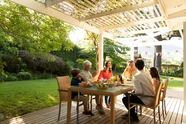 Sidovy Över Flergenerationsfamilj Kaukasus Som Sitter Utanför Vid Ett Middagsbord — Stockfoto