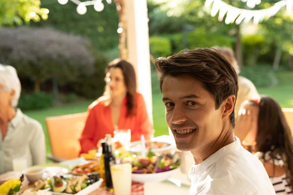 Dışarıda Ailesiyle Yemek Masasında Oturan Kameraya Gülümseyen Beyaz Bir Adamın — Stok fotoğraf