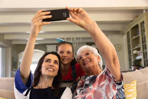 손녀와 거실의 소파에서 스마트폰을 사용하여 셀카를 — 스톡 사진