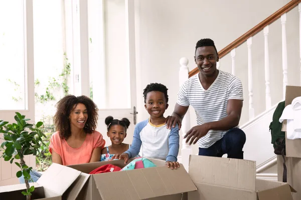 一对非洲裔美国人夫妇的画像 他们带着儿子和女儿在家里 在走廊里打开盒子 家庭享受家庭生活 生活方式概念 — 图库照片