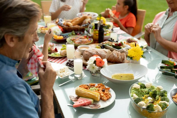 Sidovy Över Flergenerationens Kaukasiska Familj Som Sitter Utanför Vid Ett — Stockfoto