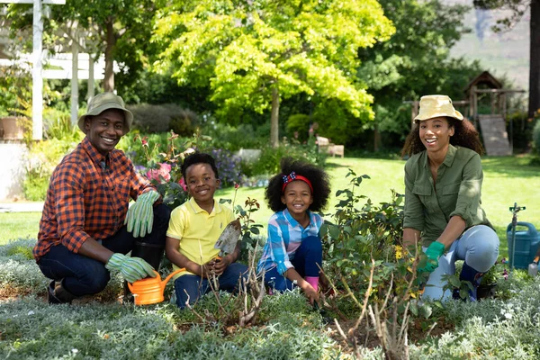 Retrato Pareja Afroamericana Con Sus Hijos Jardín Jardinería Riego Macetas —  Fotos de Stock