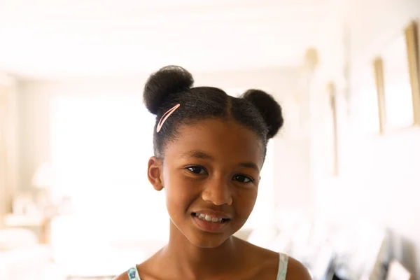 笑顔の肖像画アフリカ系アメリカ人の女の子で座っている部屋でカメラを見て自宅 — ストック写真