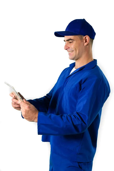 一个快乐的白人男性工程师 留着一头乌黑的短发 手持数字平板电脑 身穿工作服 头戴一顶白色背景的帽子 站在旁边观看 — 图库照片