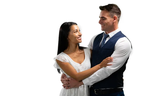 幸せな白人男性と混合人種の女性の側のビューは 愛の中で 彼らの結婚式の日に白い背景にお互いを見て抱き合って笑って — ストック写真