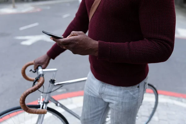 昼間は自転車を運転しスマートフォンを使って街中を歩き回っています — ストック写真
