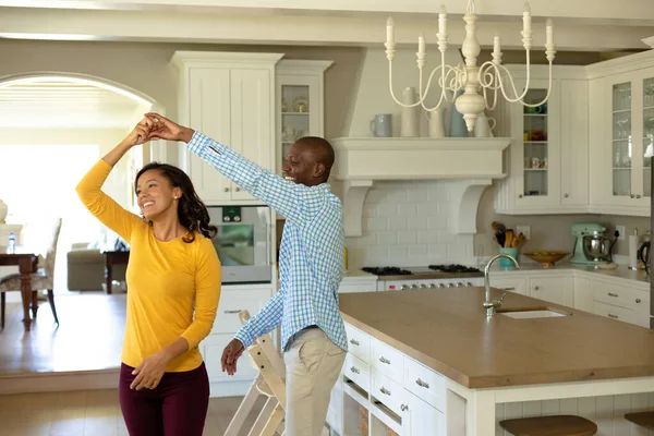 隔离隔离中的自我隔离 一个美国黑人男人和一个混血儿坐在家里奢华的厨房里跳舞 面带微笑 — 图库照片