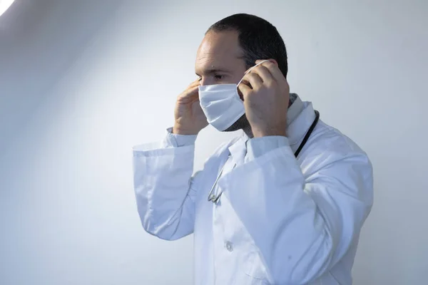 Běloch Lékařské Uniformě Stetoskopu Ramenou Obličejovou Maskou Stojící Prázdné Bílé — Stock fotografie