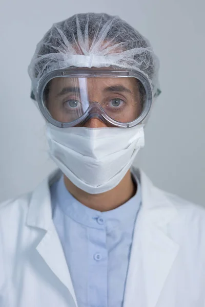 研究室のコートを身に着けている白人女性医療従事者の肖像 顔のマスクとコロナウイルスに対する保護グーグル Covid カメラにまっすぐに見て — ストック写真
