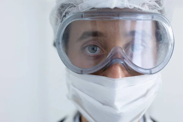 一名身穿实验室外套 戴着面具 头戴护目镜 头戴护目镜 直视摄像头的白人女性医护人员的肖像 — 图库照片