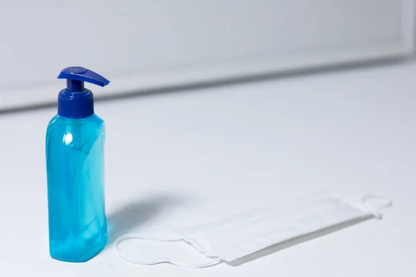 Vista Vicino Una Maschera Bianca Una Bottiglia Blu Disinfettante Contro — Foto Stock