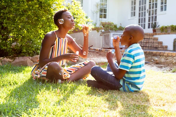 Afroameričanka Její Syn Spolu Tráví Čas Sedí Trávníku Dělají Mýdlové — Stock fotografie