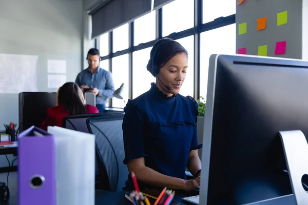 Vooraanzicht Van Een Gemengde Rassenvrouw Met Een Koptelefoon Werkend Een — Stockfoto