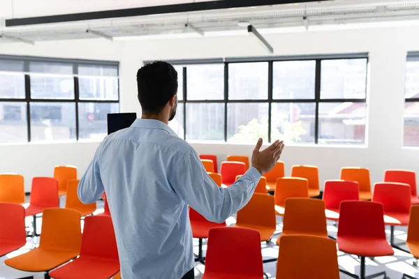一个身穿漂亮衣服的白人商人站在一间空荡荡的现代化会议室里 在会前训练自己的后视镜 — 图库照片