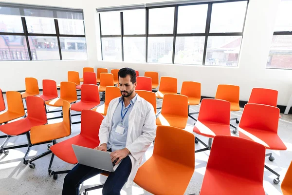 Voorzijde Van Een Blanke Mannelijke Medische Professional Laboratoriumjas Zittend Een — Stockfoto