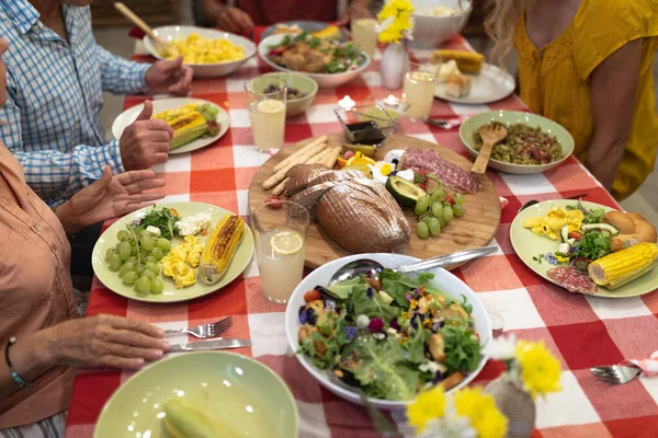 세대의 가족들이 집에서 즐거운 시간을 보내고 식탁에 음식을 식사를 합니다 — 스톡 사진