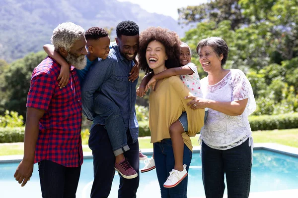 Familia Mestiza Multigeneracional Disfrutando Tiempo Jardín Con Una Piscina Pie —  Fotos de Stock