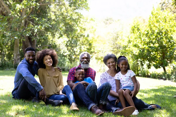 Familia Multigeneracional Raza Mixta Disfrutando Tiempo Jardín Sentados Hierba Abrazando —  Fotos de Stock