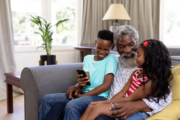 Старший Афроамериканец Внуки Наслаждаются Своим Временем Дома Вместе Сидя Диване — стоковое фото