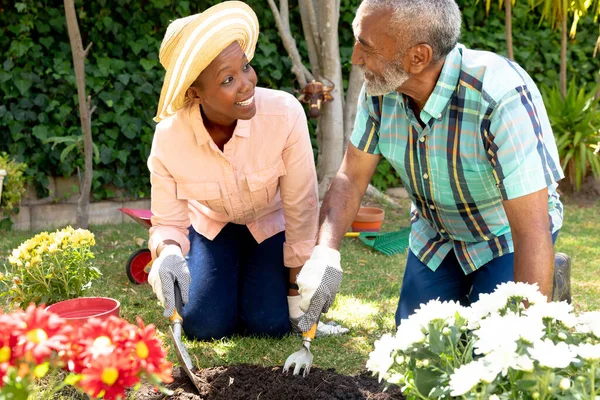 シニアアフリカ系アメリカ人のカップルは晴れた日に庭で時間を過ごし 花を植えます 隔離された封鎖における社会的距離と自己隔離 — ストック写真