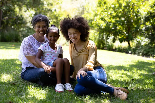 Familia Multigeneracional Raza Mixta Disfrutando Tiempo Jardín Sentados Hierba Abrazando —  Fotos de Stock