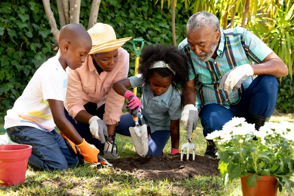 아프리카계 의연로 부부는 정원에서 손녀와 손자와 심으면서 시간을 보낸다 — 스톡 사진