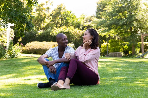 Front View Mixed Race Couple Garden Sitting Grass Talking Smiling — Stock Photo, Image